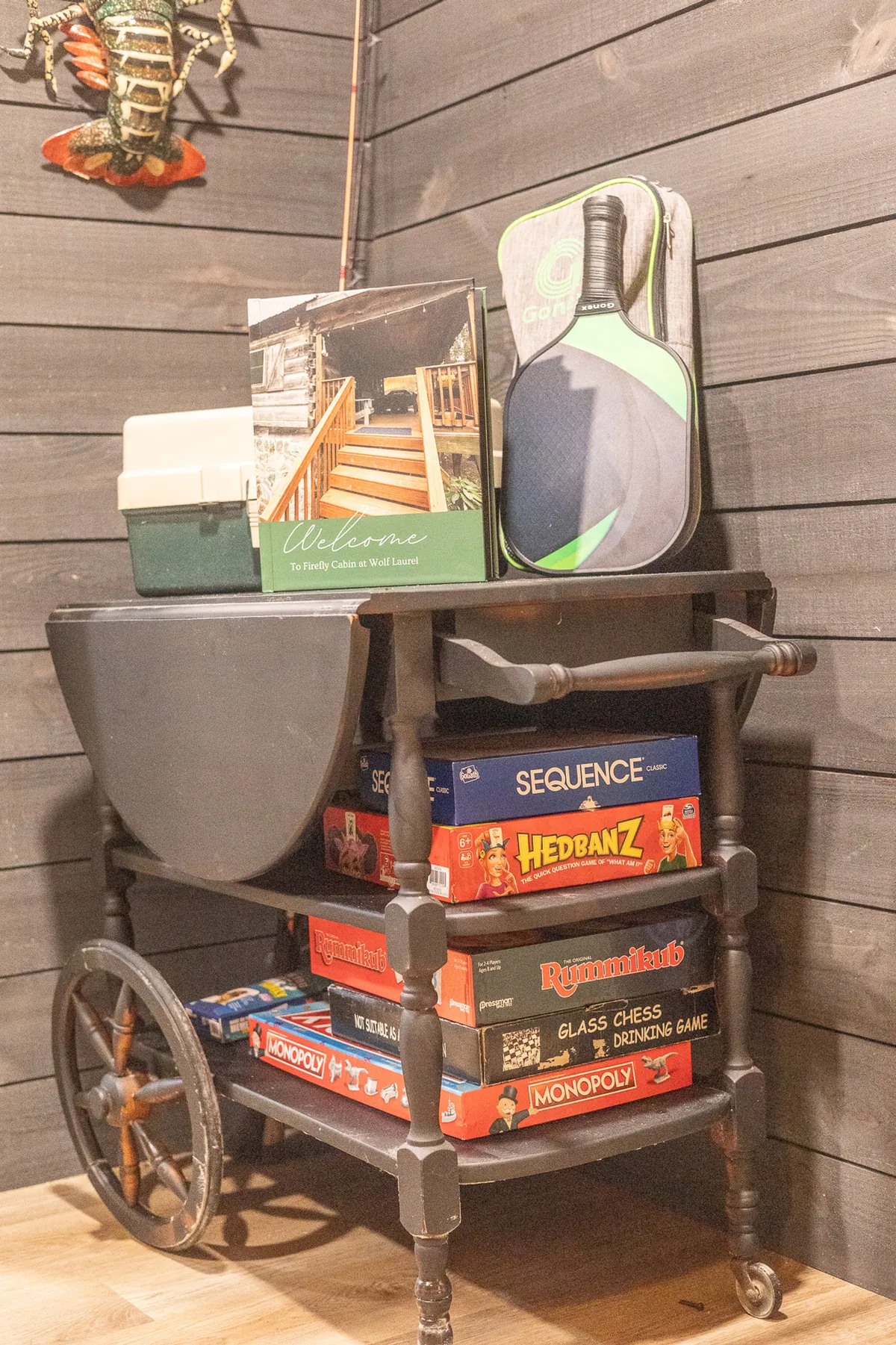 A welcoming nook with a welcome book, a collection of board games, a fishing rod, and decorative touches. The inviting layout encourages family game nights and relaxed, indoor leisure activities.